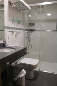 a bathroom with a toilet and a glass shower at Hotel Marina in Peniscola