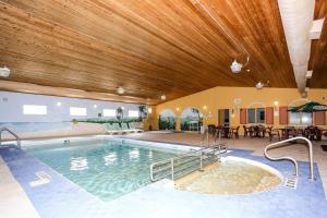 a large swimming pool in a building with a wooden ceiling at Altona Hotel in Altona