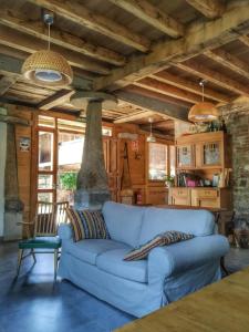 a living room with a blue couch in a house at La Figal de Xugabolos, Salas in Salas