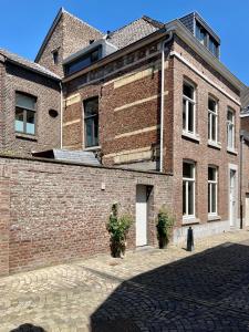 a brick building with a white door and a brick wall at Besselaar Apartments in Maastricht