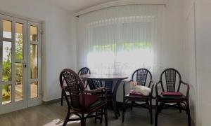 une salle à manger avec une table, des chaises et un chat assis sur la table dans l'établissement Apartments Andrej, à Ptuj