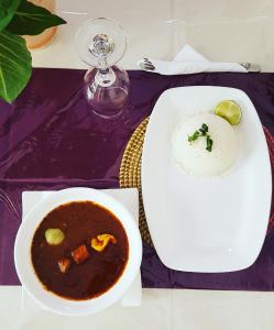 a table with a plate of soup and a bowl of rice at Hôtel Saint-Louis Sun Dakar in Dakar