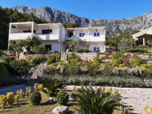 a view of a house with mountains in the background at Apartman Mare in Drvenik