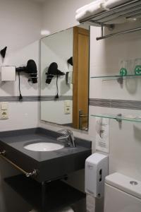 La salle de bains est pourvue d'un lavabo et d'un miroir. dans l'établissement Hotel Marina, à Peñíscola
