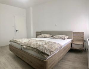 a bedroom with a large bed with white sheets and pillows at Apartments Andrej in Ptuj