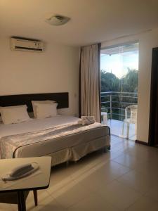 1 dormitorio con 1 cama grande y balcón en Valparaiso Hotel en Cruz das Almas