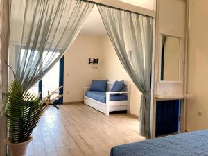 ein Schlafzimmer mit einem Bett, einem Sofa und einem Spiegel in der Unterkunft Michail Suites Afiartis Karpathos in Karpathos