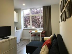 un soggiorno con divano e una cucina con tavolo di Romantic 1 Bedroom Apartment at Roma Avenue - 1C a Lisbona