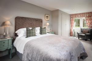 a bedroom with a large bed and a chair at Throphill Grange in Morpeth