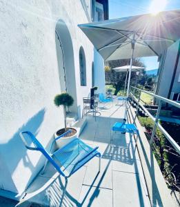 eine Terrasse mit blauen Stühlen und einem Sonnenschirm in der Unterkunft Bed and Breakfast Olten in Olten