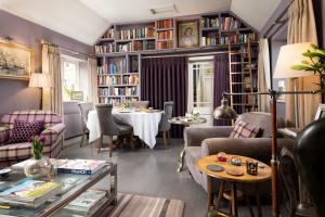 a living room with a table and bookshelves at Throphill Grange in Morpeth