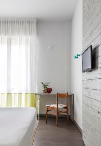 una camera con letto, sedia e TV di Hotel Madison a Rimini