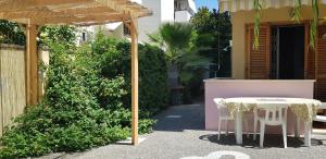 ガリポリにあるAppartamento con giardino sul mareの建物の隣のパティオ(テーブル、椅子付)