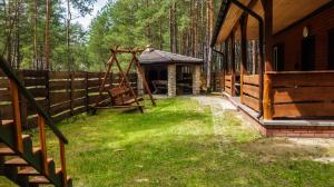 une cour avec une balançoire et une clôture en bois dans l'établissement Domek Nad Wodą, à Majdan Sopocki