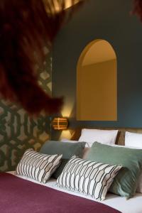 a bedroom with two beds with pillows and an archway at MiHotel Tour Rose in Lyon