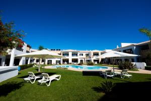 a resort yard with chairs and a swimming pool at Sagres Time Apartamentos in Sagres