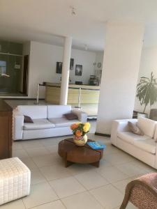 una sala de estar con 2 sofás blancos y una mesa. en Valparaiso Hotel en Cruz das Almas