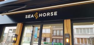 un panneau à l'avant d'un magasin de chevaux de mer dans l'établissement Hotel Des Zouaves, à Coxyde