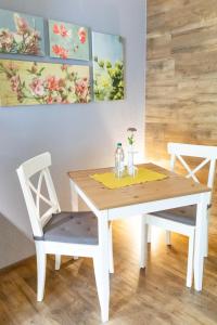 a white dining room table and chairs with a yellow napkin at Ferienwohnung s' Plätzli in Freiamt