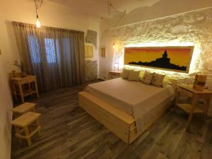 sypialnia z łóżkiem i obrazem na ścianie w obiekcie B&B François le cordonnier maison de charme w mieście Santa Teresa Gallura