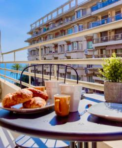 a table with a plate of food on a balcony at #29 Suite Gambetta AC Sea view 2 bedrooms 1min Walk to Promenade & Sea in Nice