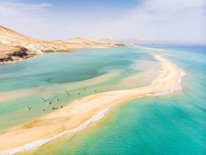 uma vista aérea de uma praia com pessoas na água em Playa Paraiso em Costa Calma