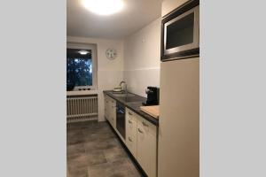 uma cozinha com um lavatório e um micro-ondas em Ferienwohnung Wohnung Krefeld Forstwald Höltehoffe em Krefeld