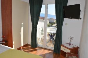 a bedroom with a bed and a view of a patio at Apartman Mare in Drvenik