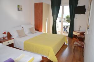 a hotel room with two beds and a balcony at Apartman Mare in Drvenik