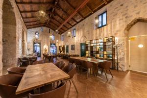 Heritage Hotel Maskovica Han في باكوشتاني: غرفة طعام مع طاولات وكراسي خشبية