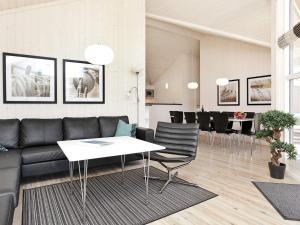 ein Wohnzimmer mit einem Sofa, einem Tisch und Stühlen in der Unterkunft 10 person holiday home in Gro enbrode in Großenbrode