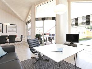 ein Wohnzimmer mit einem weißen Tisch und Stühlen in der Unterkunft 10 person holiday home in Gro enbrode in Großenbrode