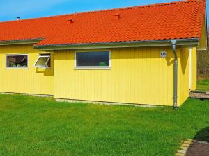 a yellow house with an orange roof at 8 person holiday home in Gro enbrode in Großenbrode