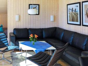 a living room with a black couch and a table at 8 person holiday home in Gro enbrode in Großenbrode