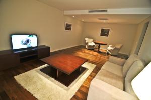 a living room with a couch and a tv at Altos del Arapey All Inclusive, Golf & Spa in Termas del Arapey
