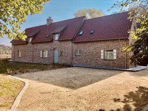 uma grande casa de tijolos com uma grande entrada em Oscaar vakantiewoning in bos em Koekelare