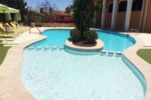 uma piscina com uma palmeira no meio em Casa con Encanto en Pueblo Acantilado em El Campello