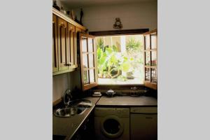 cocina con fregadero y ventana en Casa con Encanto en Pueblo Acantilado, en El Campello