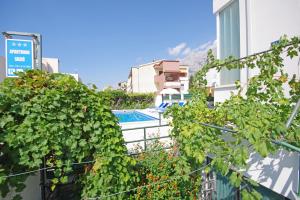 vista sulla piscina da un edificio con piante di Apartmani Srzic a Makarska