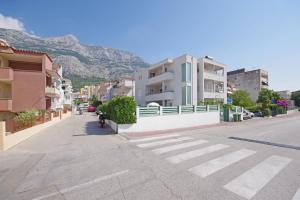 a city street with buildings and a mountain in the background at Apartmani Srzic in Makarska