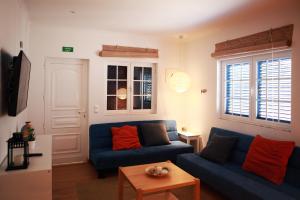 a living room with a blue couch and a table at Casal Do Góis Guest House in Atouguia da Baleia
