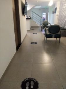 un pasillo con 2 sillas y una planta con sala de espera en Hotel Grato Manizales en Manizales