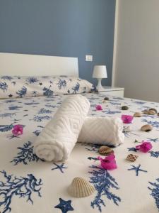 Una cama con una toalla y conchas. en B&B Campitur, en Campomarino