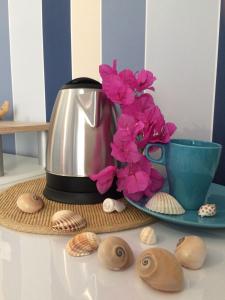una tetera y conchas de mar en una mesa junto a una taza en B&B Campitur, en Campomarino