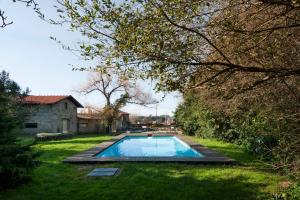 a swimming pool in the middle of a yard at Casa do Sobreiro in Pedroso