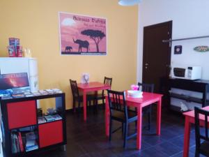 a room with red tables and chairs and a sign on the wall at B&B Scirocco D'Africa in Catania +29 photos