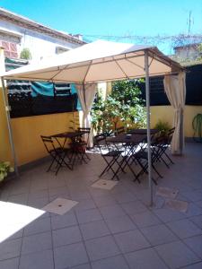 un tavolo e sedie sotto un ombrellone su un patio di B&B Scirocco D'Africa a Catania