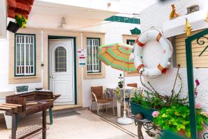 un patio con una mesa y una sombrilla en Casas da Bela - Bairro Típico na Nazaré, en Nazaré
