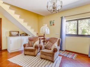 a living room with two chairs and a staircase at Striking Holiday Home in Carcavelos with Swimming Pool in Carcavelos