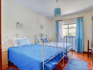 a bedroom with a blue bed and a window at Striking Holiday Home in Carcavelos with Swimming Pool in Carcavelos